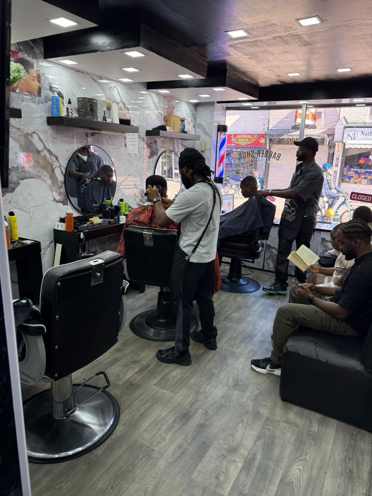 Inside Baba Yaro Barbers on Church Gate, with barbers cutting at two chairs.